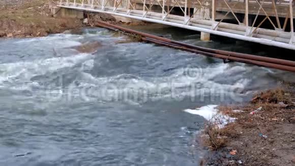 桥下河流在城市中快速流动生锈的管道铺设在河对岸视频的预览图