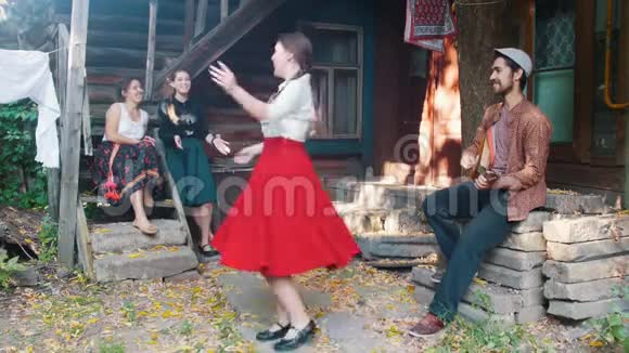 一个穿红色裙子的女人在音乐中跳舞一个男人在演奏巴拉莱卡视频的预览图