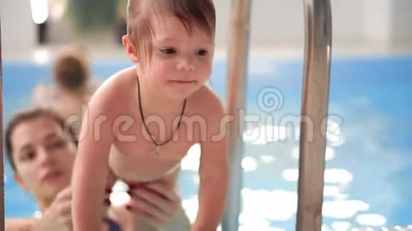 婴儿从游泳池上楼来帮助母亲慢动作视频的预览图