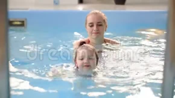 婴儿从游泳池上楼来帮助母亲慢动作视频的预览图