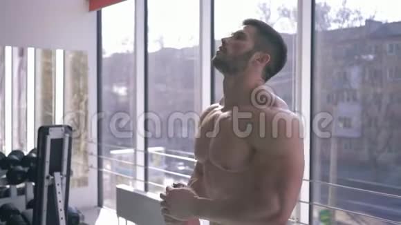 肌肉魅力健美运动员正在运动健身馆的力量训练旁边喝蛋白奶昔饮料视频的预览图