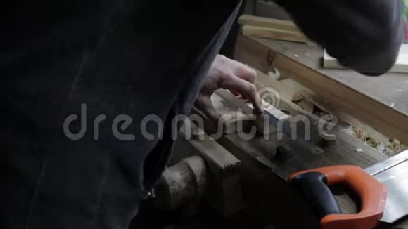 男木匠把木板贴在松木架子上用锯条测量是否合适并加以标记视频的预览图
