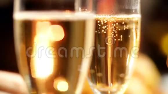 在圣诞节的夜晚两个装满香槟的杯子在燃烧的火花中的特写慢动作视频完美完美完美视频的预览图