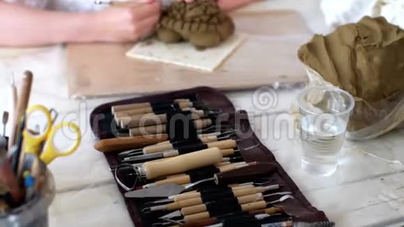 小女孩在艺术作坊用湿粘土和特殊工具雕刻海龟视频的预览图