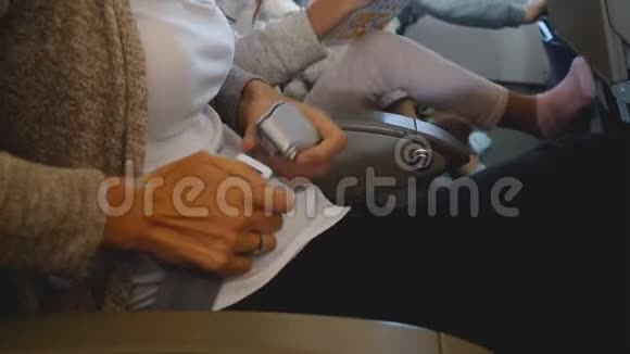 在与家人一起度假的飞机飞行中女性双手系好安全带的特写镜头安全概念视频的预览图