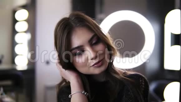 快乐年轻的女孩与完美完成的化妆和美丽的耳环看相机皮肤光滑的女人视频的预览图