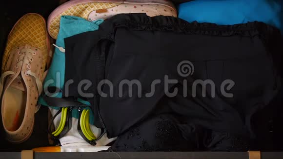 女人手正在收拾旅行箱上景毛巾和其他东西那个女孩正准备飞往视频的预览图