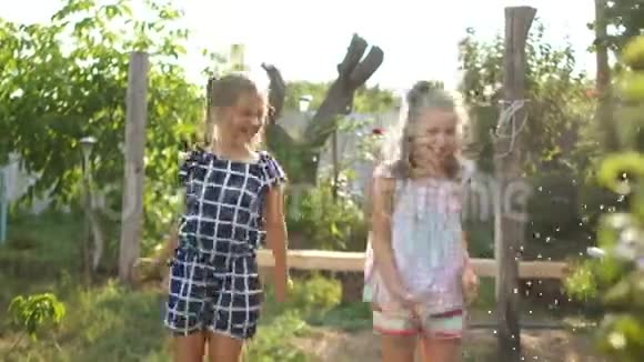 在村里度假的女学生两个女孩玩得开心跳在水里孩子们玩得开心视频的预览图