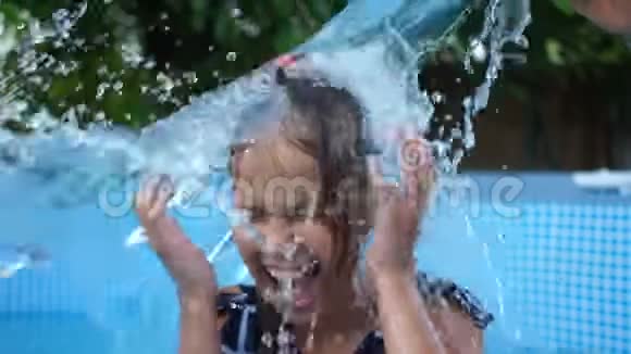 可爱的小女孩在游泳池里玩得很开心在水中飞溅在不同的侧面喷洒快乐的童年夏天视频的预览图