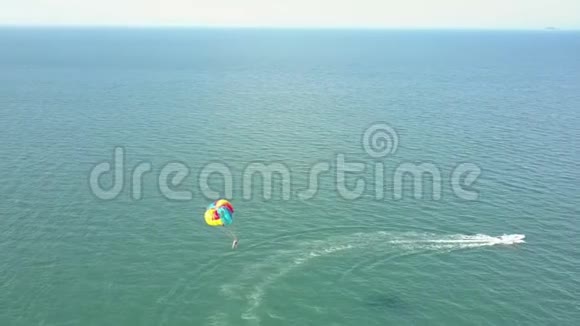 空中观景降落伞在白色摩托艇后在海上飞行视频的预览图