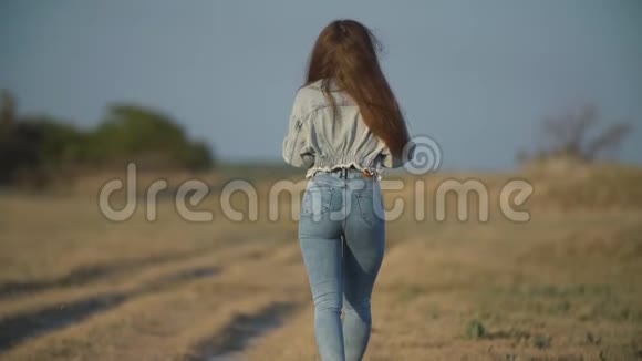 穿牛仔裤的女孩沿路走视频的预览图