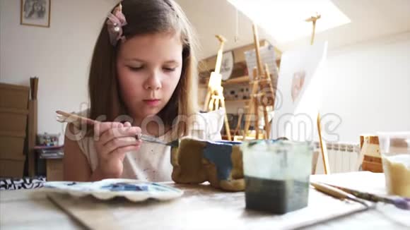 小女孩正在用蓝色绘画她的手工玩具是在艺术车间用粘土做的视频的预览图