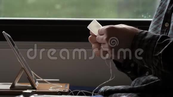 人在火车上用餐巾纸清洗和擦拭耳机视频的预览图