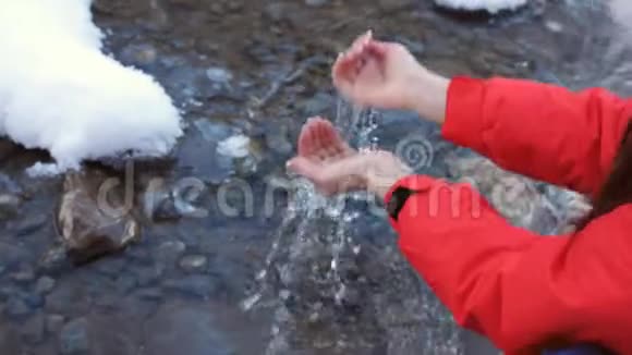冬天女人的特写镜头正从一条山河里获得干净清澈的水和饮料视频的预览图