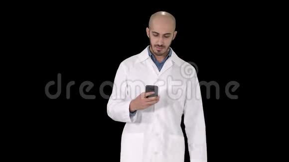 男阿拉伯医生走路时在电话上发短信阿尔法频道视频的预览图