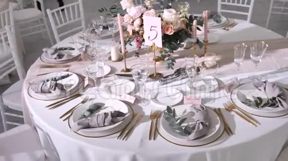为客人提供现代风格的婚礼桌上装饰玫瑰和桉树的插花粉彩视频的预览图