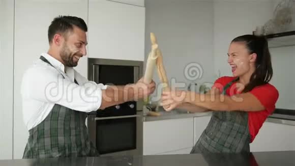 有趣的一对夫妇假装在家里一起做饭时和餐具工具打架夫妻俩玩得开心视频的预览图
