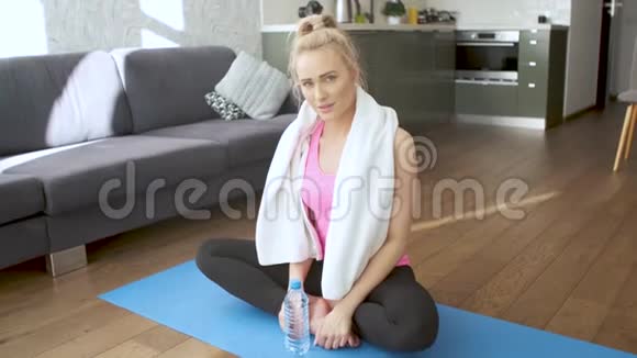 美丽的中年金发女性在身体锻炼后用毛巾擦汗视频的预览图