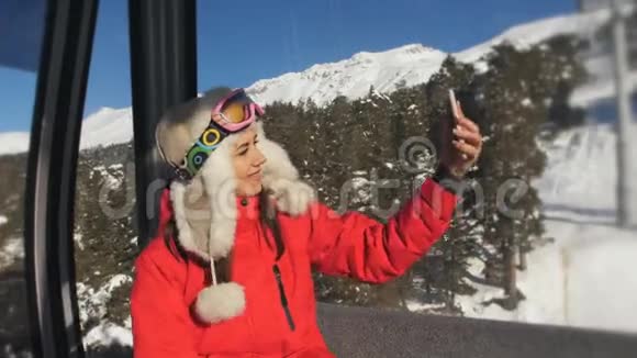 女人在机舱滑雪电梯的智能手机上自拍视频的预览图