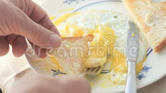 男人用烤面包片舀鸡蛋视频的预览图