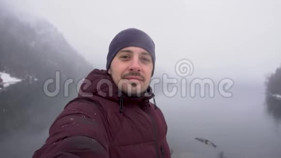 冬天人们在阿布哈兹的里萨湖上自拍并展示拇指视频的预览图