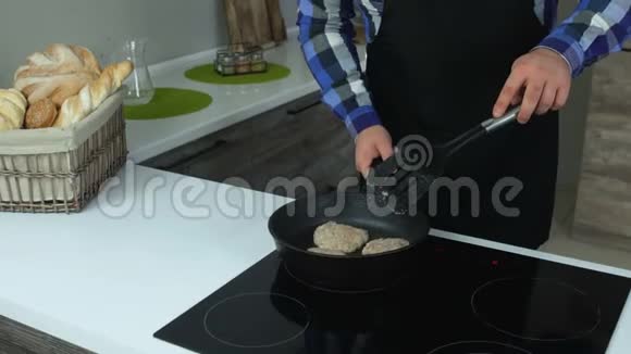 一个胖子在厨房的平底锅里炸自制的汉堡馅饼不健康的生活方式油炸和有害的高热量视频的预览图