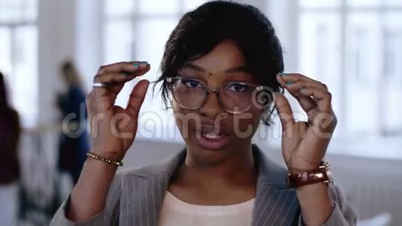 专业年轻的非洲经理商务女性调整眼镜的特写肖像在现代办公室摆姿势视频的预览图