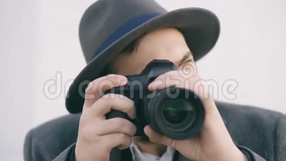 可疑的年轻摄影师给你拍照戴帽子的时髦男间谍的概念视频的预览图
