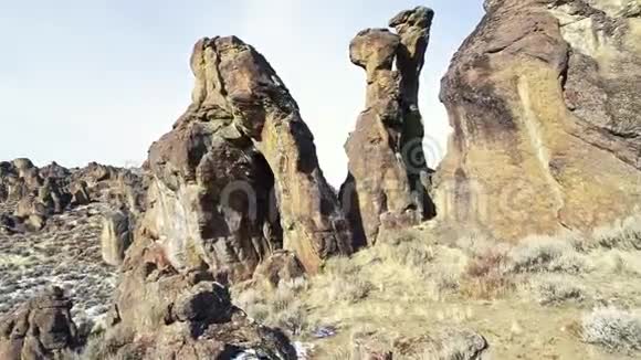 裸露的岩石尖顶在沙漠峡谷的地面之上视频的预览图