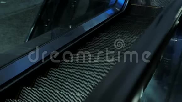 一个空的移动楼梯在夜间向下运行的特写镜头现代自动扶梯楼梯移动室内搬迁视频的预览图