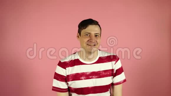 男人在粉红色的背景上微笑男性眨眼概念调情视频的预览图