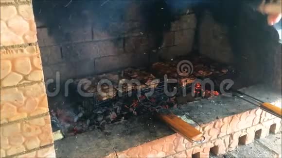 猪肉羊肉或鸡肉肉片被烧在木炭烤架上曼格尔女人的手用特殊的装置吹火烘干视频的预览图