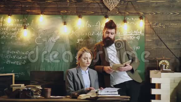 女人在一台打字机上打印文字在绿色黑板背景下胡须男的口述视频的预览图