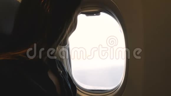 大气特写镜头快乐放松的乘客妇女享受从飞机窗口的景色并关闭它视频的预览图
