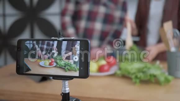 网络视频博客智能手机为博客的人制作视频让他们知道博客的男人和女人是如何从健康的食物中烹饪的视频的预览图