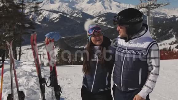 几个滑雪者在下一次下山前休息欣赏冬天的风景视频的预览图