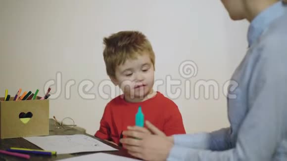 妈妈和儿子一起玩一起画画孩子和母亲用白色的铅笔画视频的预览图