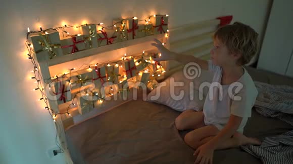 一个小男孩慢镜头从一张挂在床上的历法中取出一份礼物视频的预览图