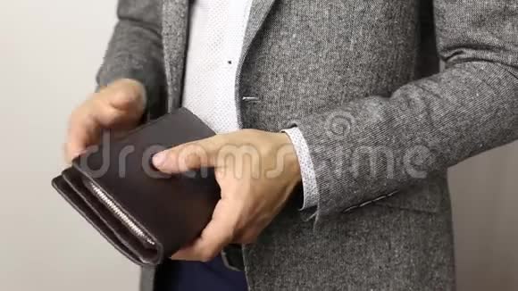 穿着白色背景灰色夹克的壮汉从钱包里掏出三百美元钞票清点钞票视频的预览图