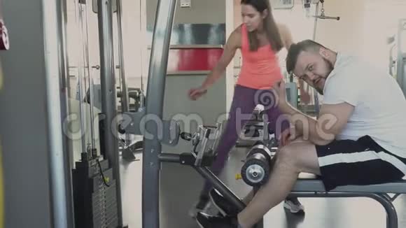 超重男子在健身房和私人教练混在一起真是可笑个人减肥训练视频的预览图
