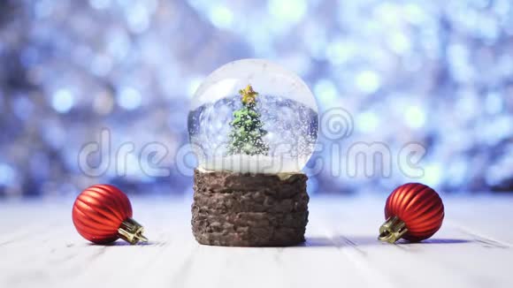 在一个玻璃球内的圣诞树上雪花飞舞视频的预览图