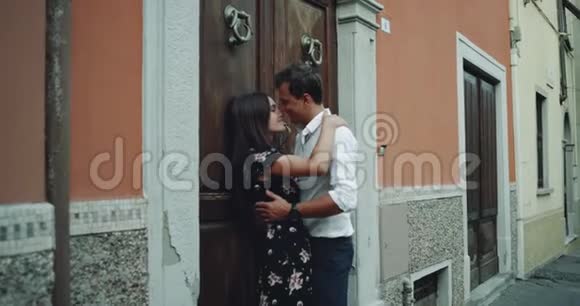 在意大利一条古老的小街中间一位年轻的女士和一位性感的房子的旁边拥抱着对方视频的预览图