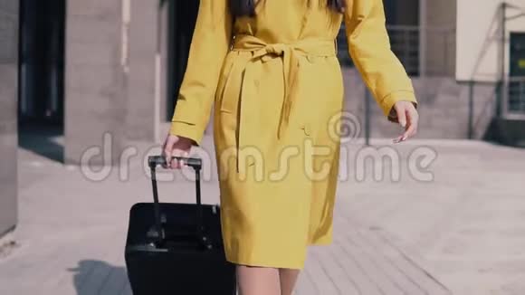 穿着黄色雨衣帽和带行李的眼镜留着深色长发的时髦女孩坐出租车视频的预览图