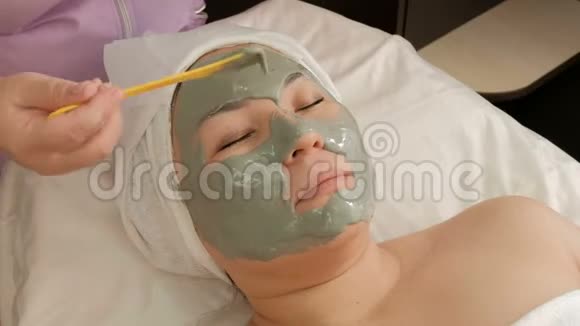 特写镜头在东亚妇女脸上涂海藻酸盐面膜的美容程序一位专业的美容师视频的预览图