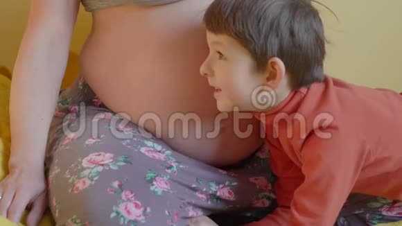 小男孩在听妈妈怀孕的肚子视频的预览图