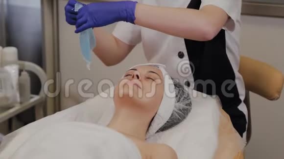 专业美容师将透明面料面膜敷于面部视频的预览图