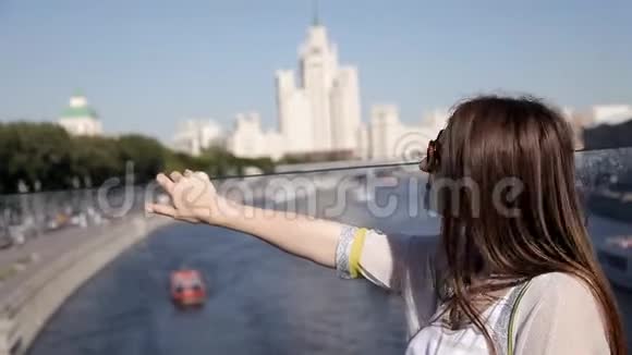 年轻的微笑模特金发碧眼摆在河边一栋房子的桥上视频的预览图