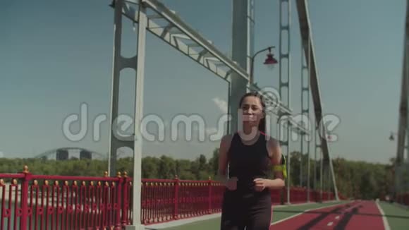 在行人天桥上奔跑的亚洲女性慢跑者视频的预览图