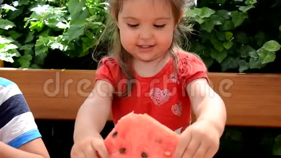 有趣的肖像一个令人难以置信的美丽的小女孩吃西瓜健康的水果小吃可爱的蹒跚学步的孩子视频的预览图
