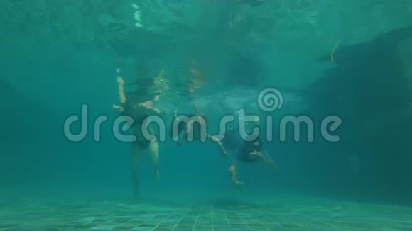 慢动作水下拍摄一个幸福的家庭在游泳池潜水健康的生活方式积极的父母视频的预览图
